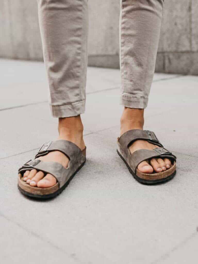 Lower half of a person wearing sandals.