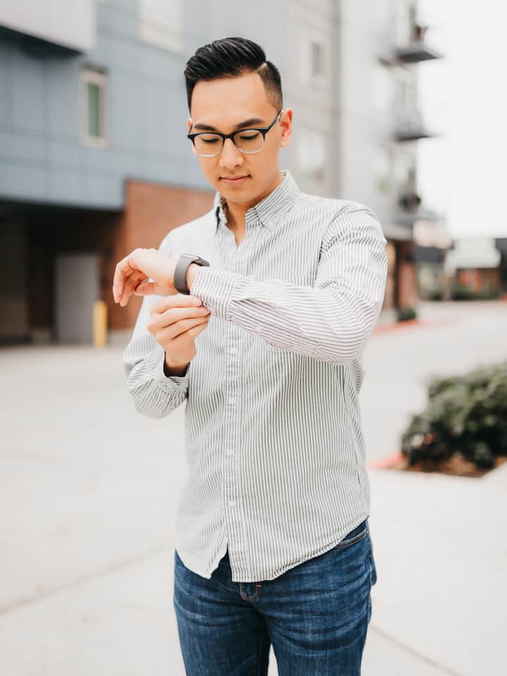 Person unbuttoning the sleeve of their shirt.