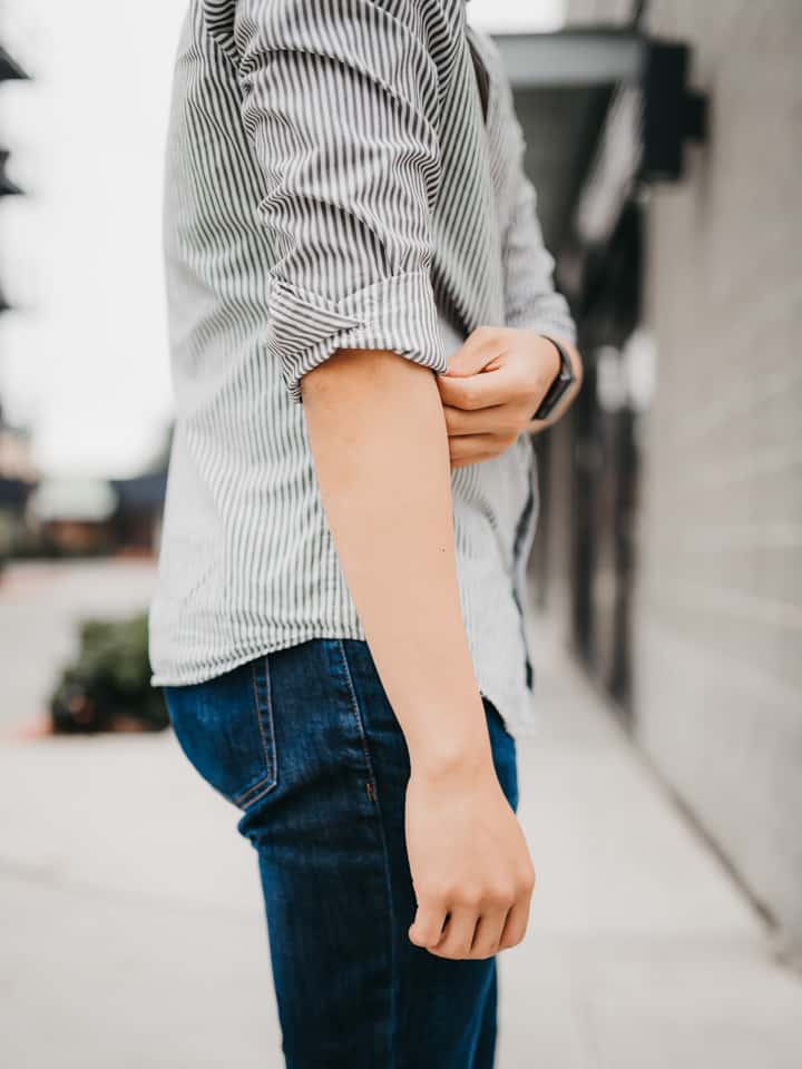 Close-up of a person with rolled sleeves.