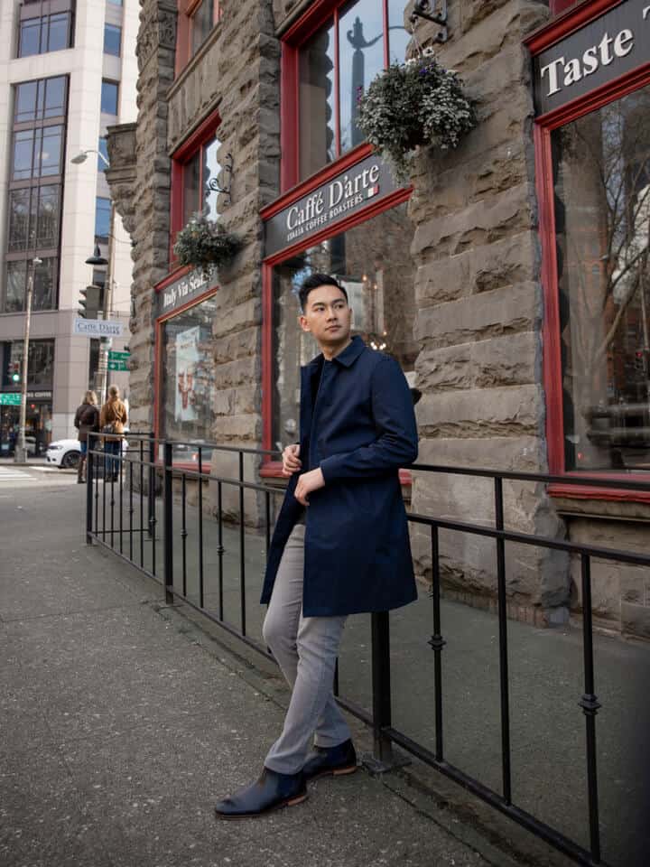 Person leaning on a railing near a coffee shop.