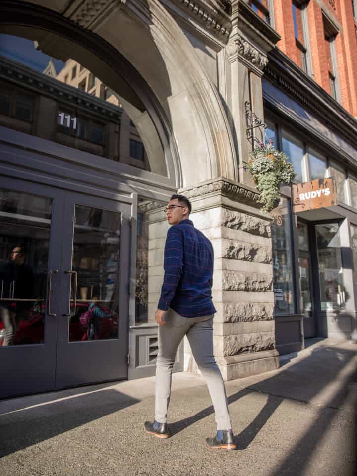 Person looking to the side while walking towards a building.