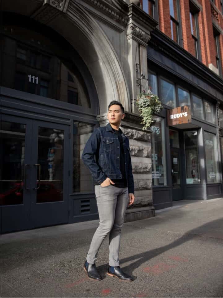 Man with grey jeans and a denim jacket.