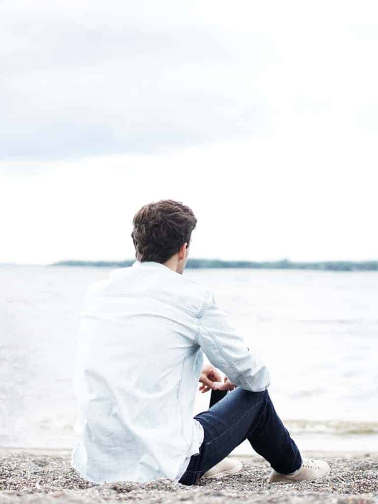 A man sitting on gravel.