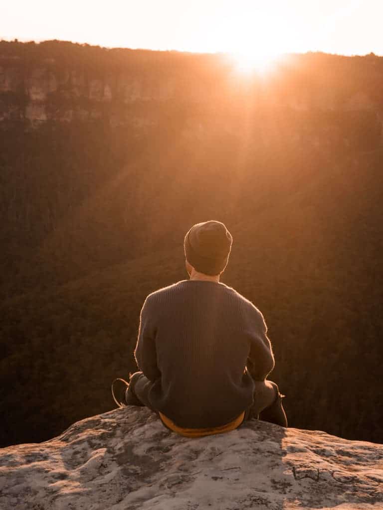 Person sitting on a cliff.