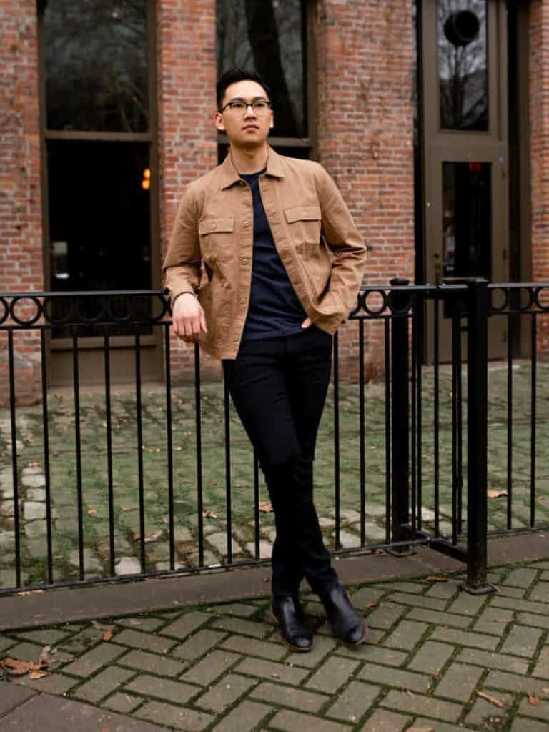 Person leaning on a gate in front of a building.