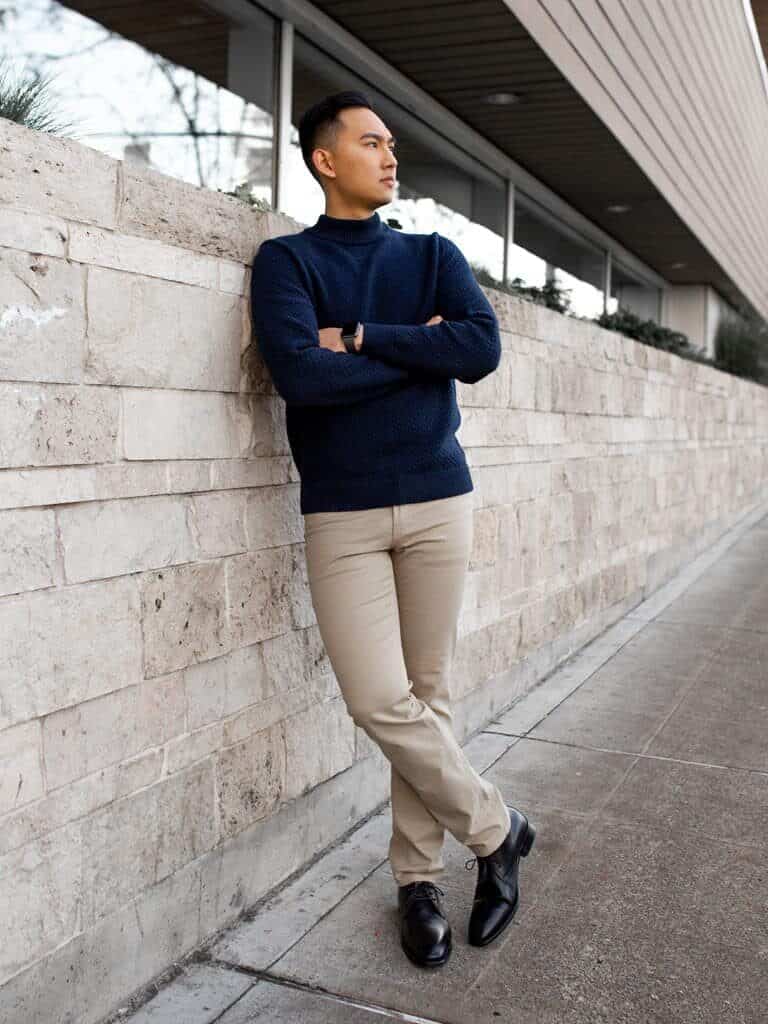 Person leaning on a brick wall and looking to the side.