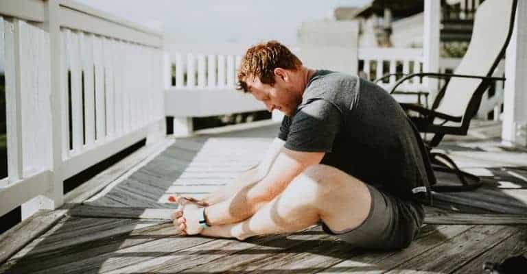 Person stretching on a porch.