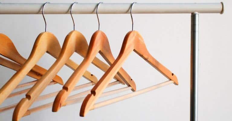 Wooden hangers on a bar.