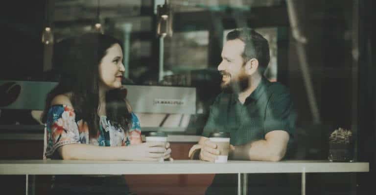 Two people talking in a coffee shop.