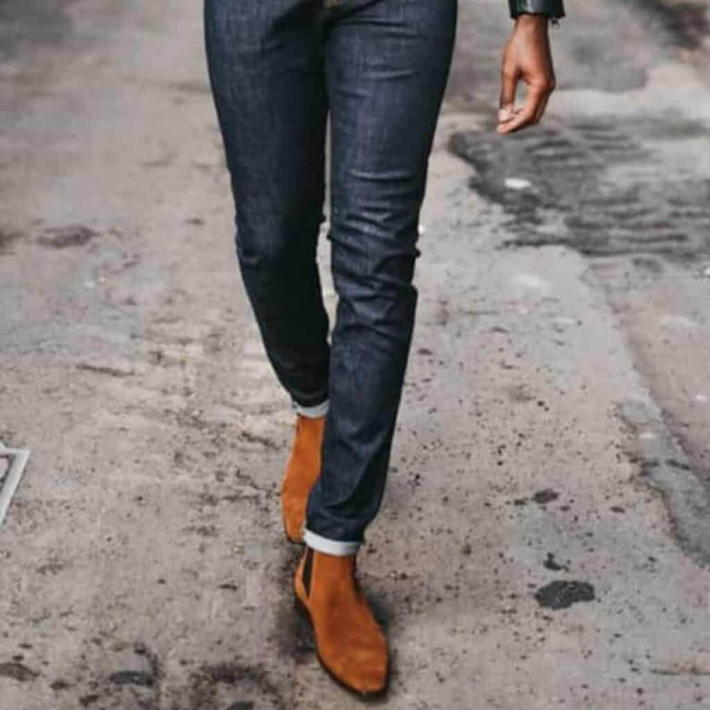 Lower half of a man wearing jeans and boots.