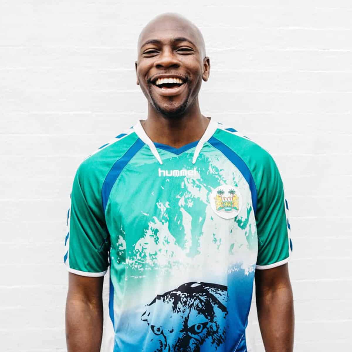 A smiling man wearing a soccer jersey.