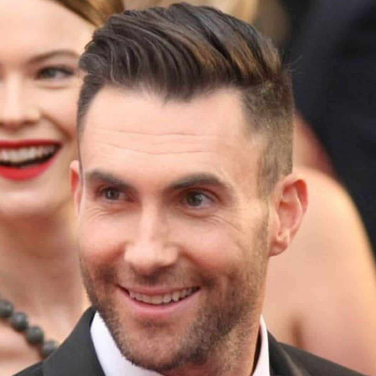 Headshot of Adam Levine wearing a suit.