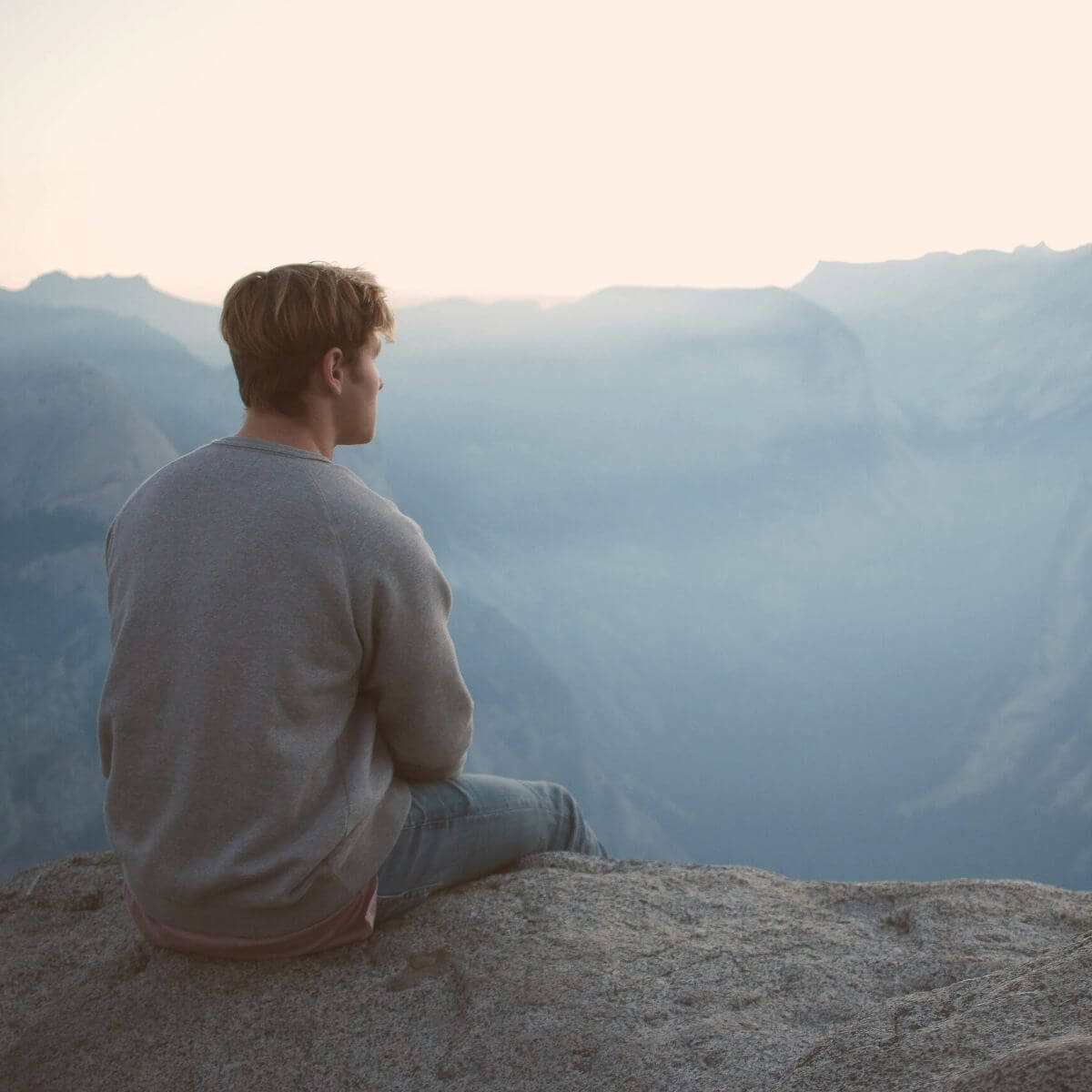 Person sitting on a cliff.