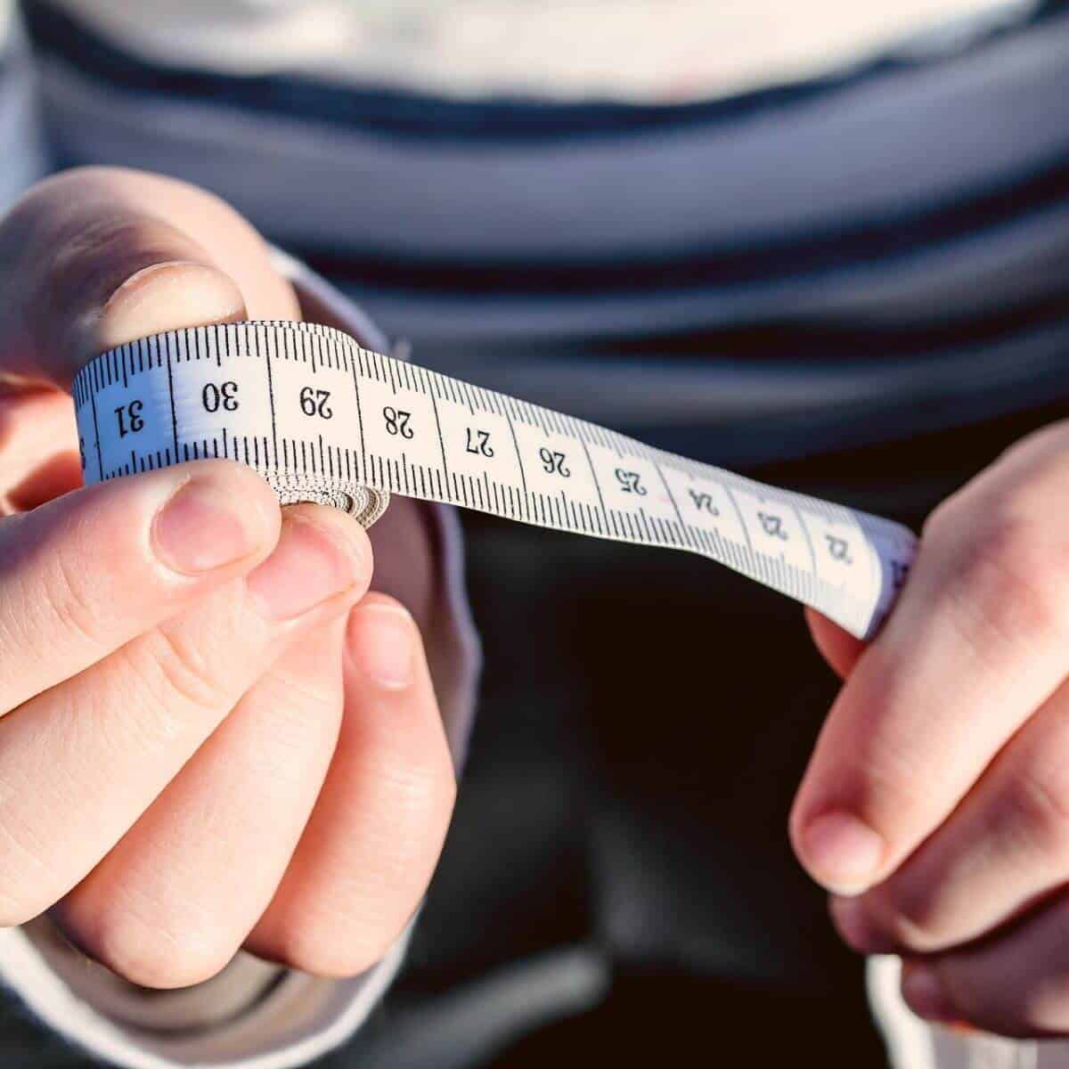 Close-up of hands holding a tape measure.