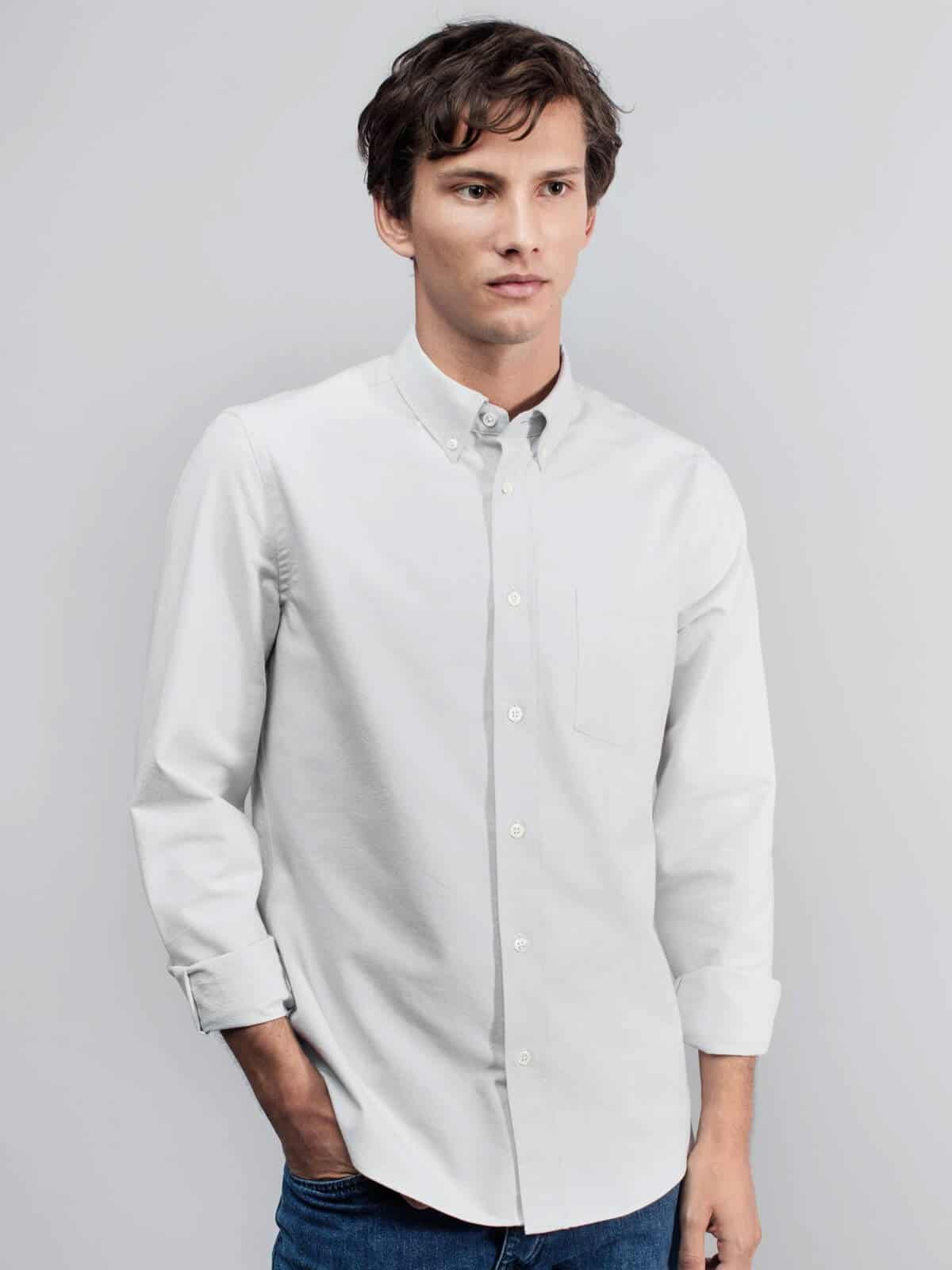 Person wearing a grey button-up with blue jeans.