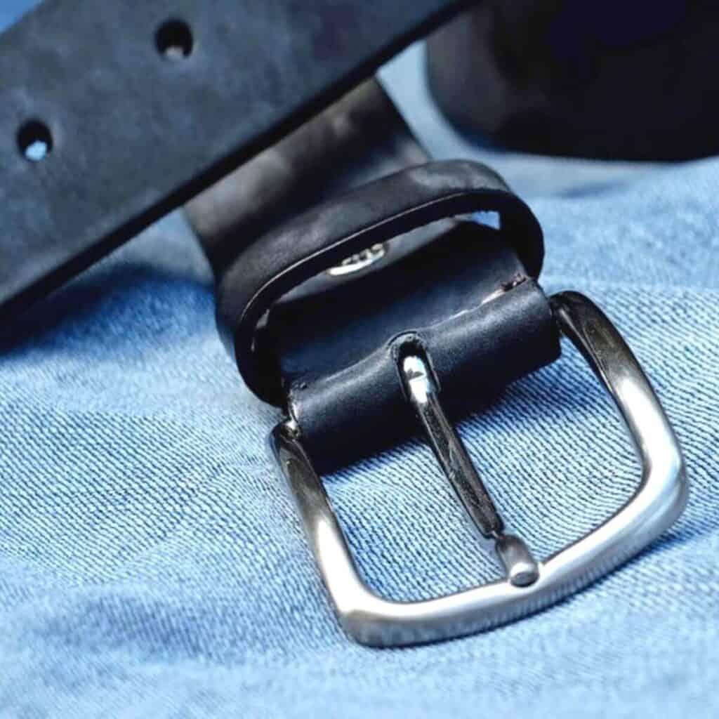Close-up of a black leather belt.