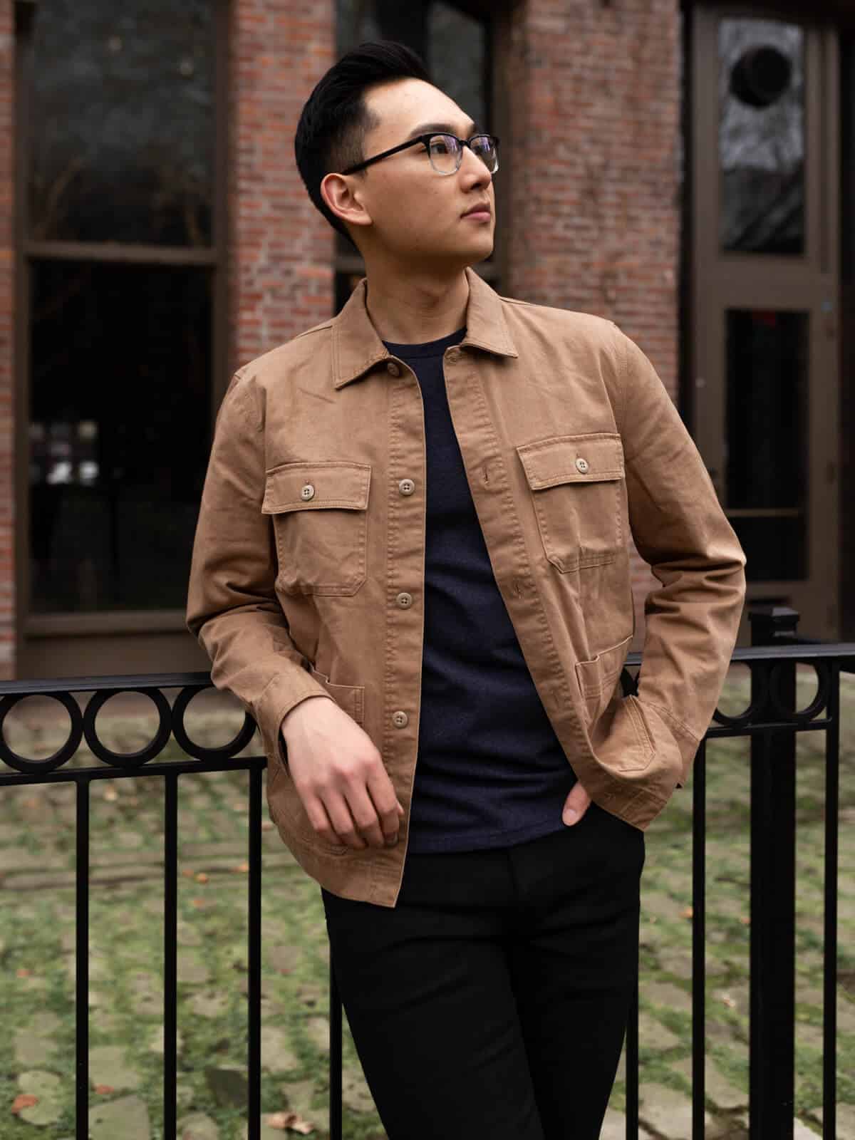 Person leaning on a railing in front of a building.