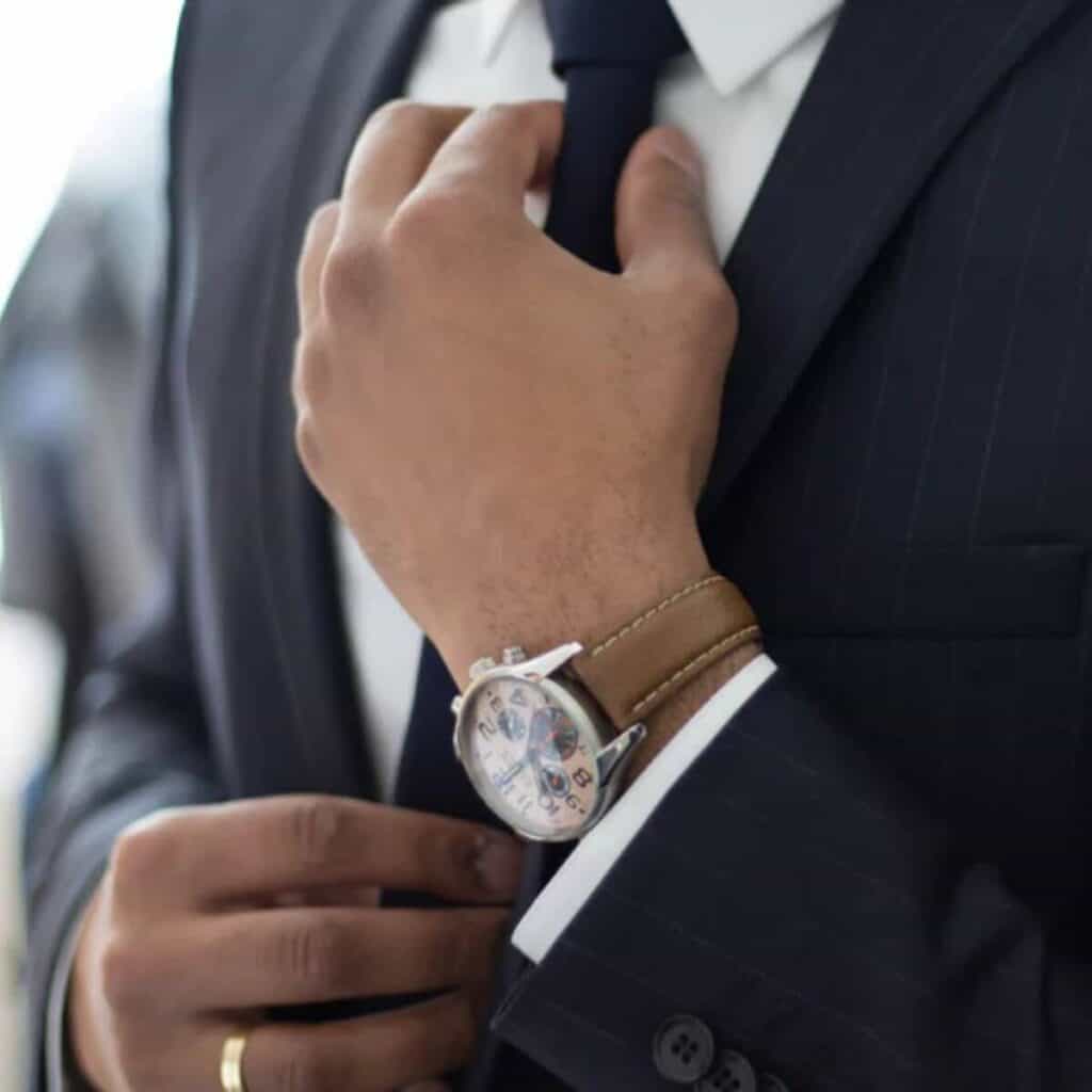 Close-up of a person fixing their tie.