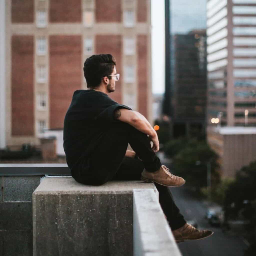 Person sitting on the edge of a building.