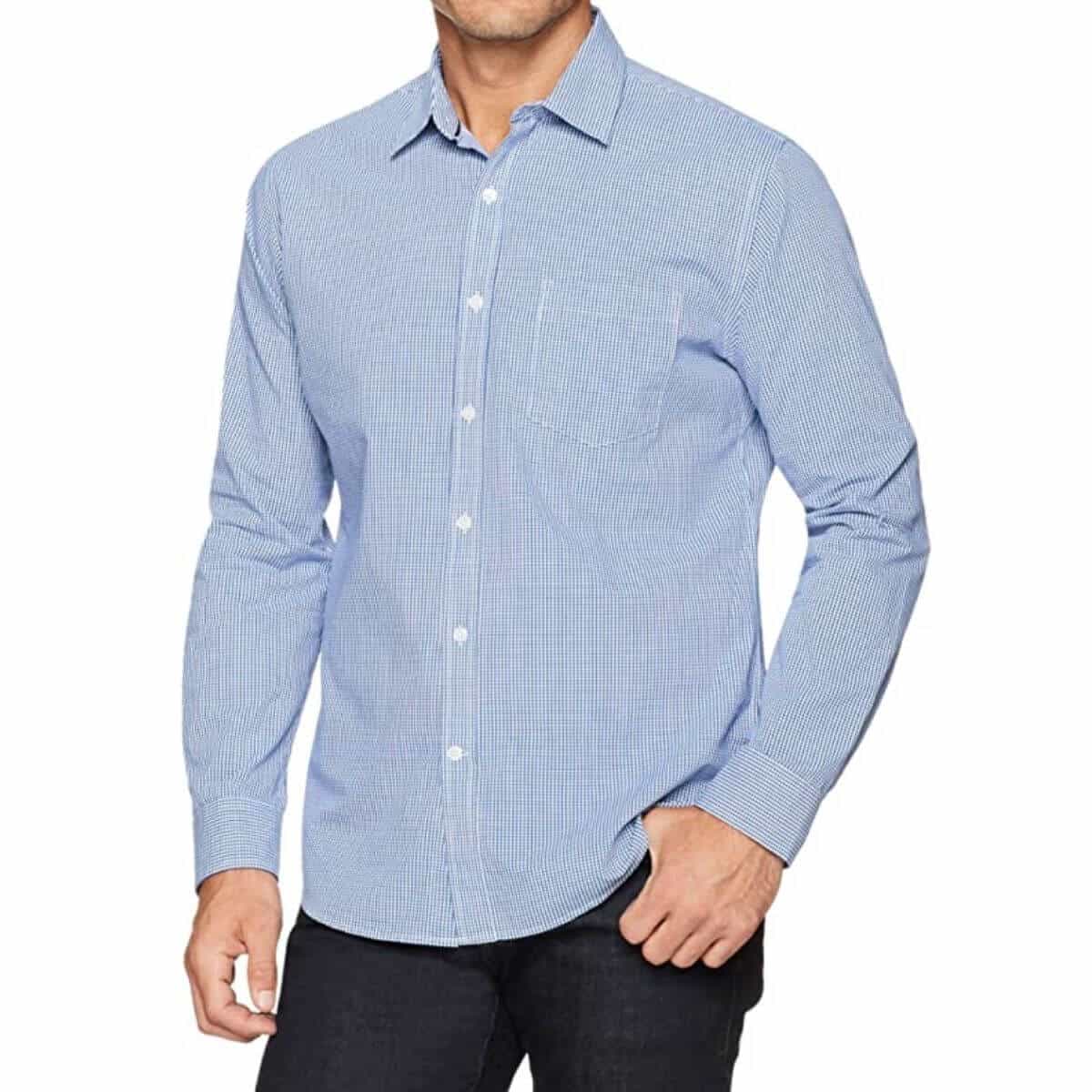 Top half of a person wearing a blue gingham shirt and dark jeans.
