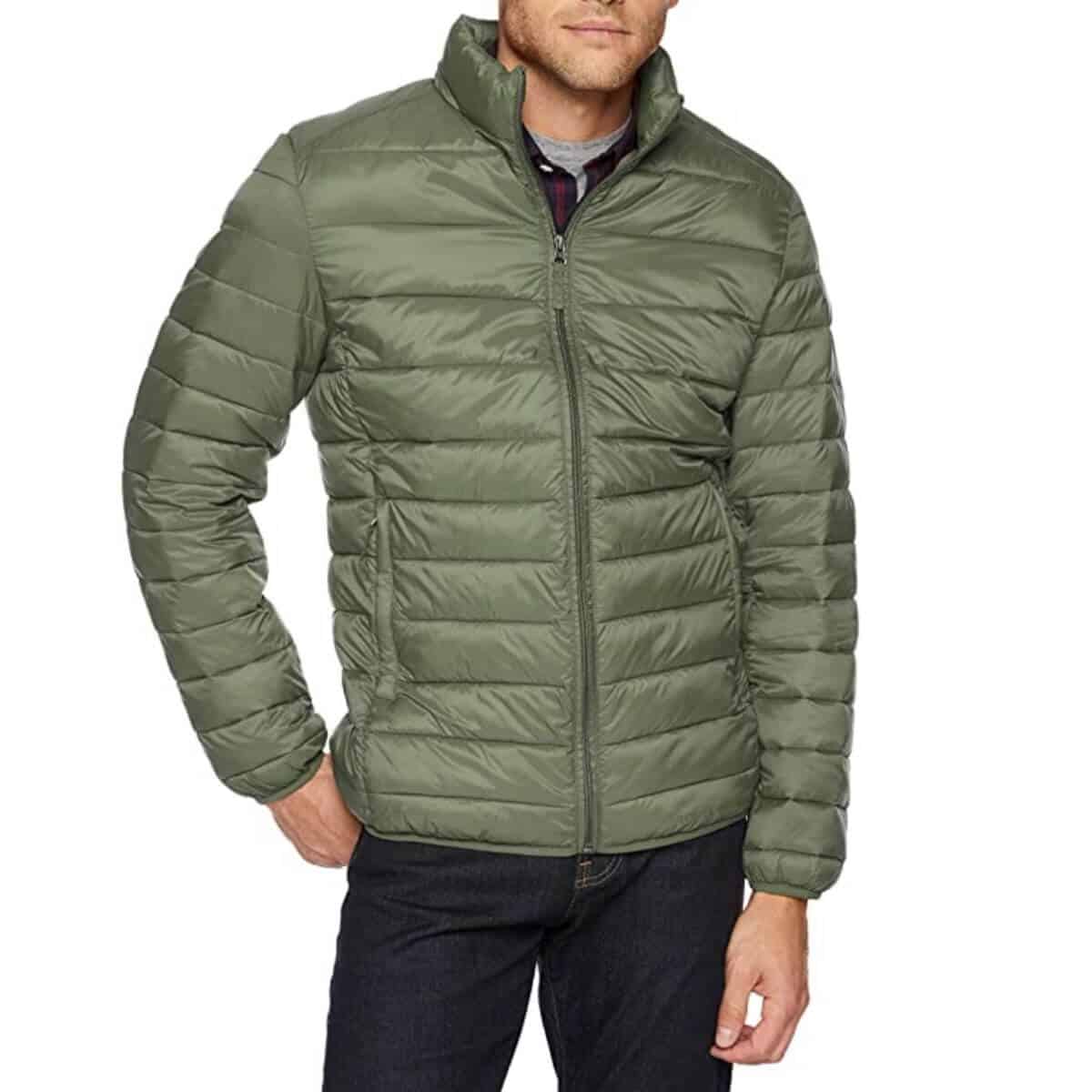 Top half of a person wearing an olive green puffer jacket with dark jeans.