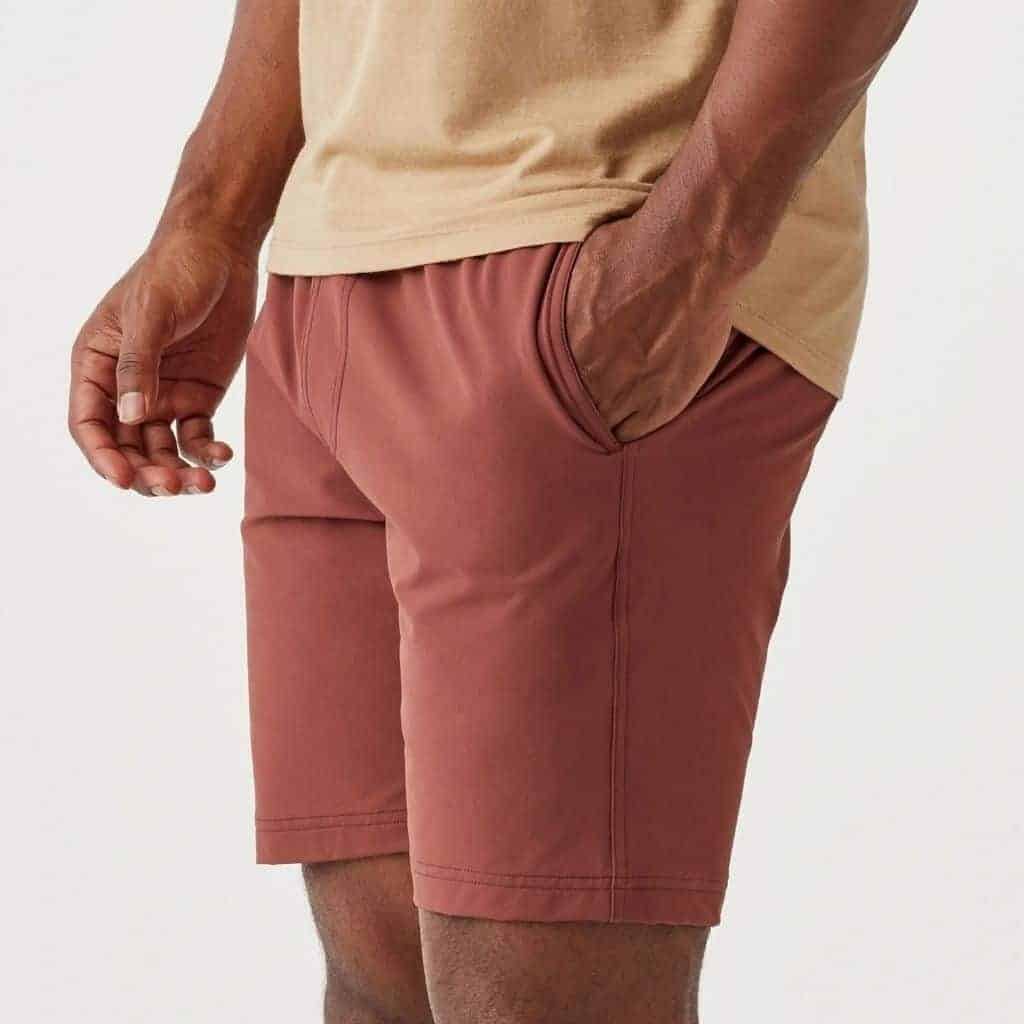 Close-up of a person wearing muted red shorts.