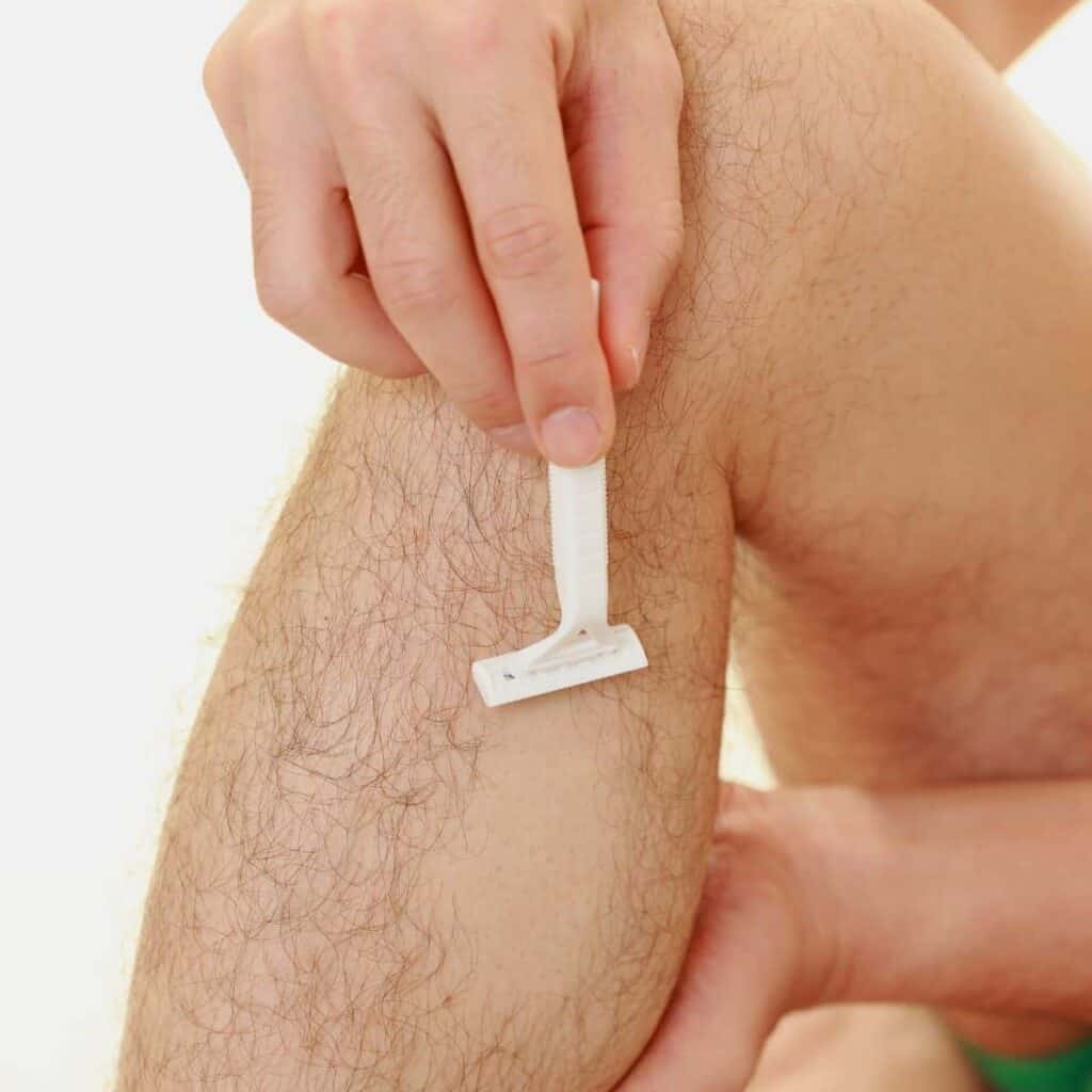 Close-up of a person shaving their leg.