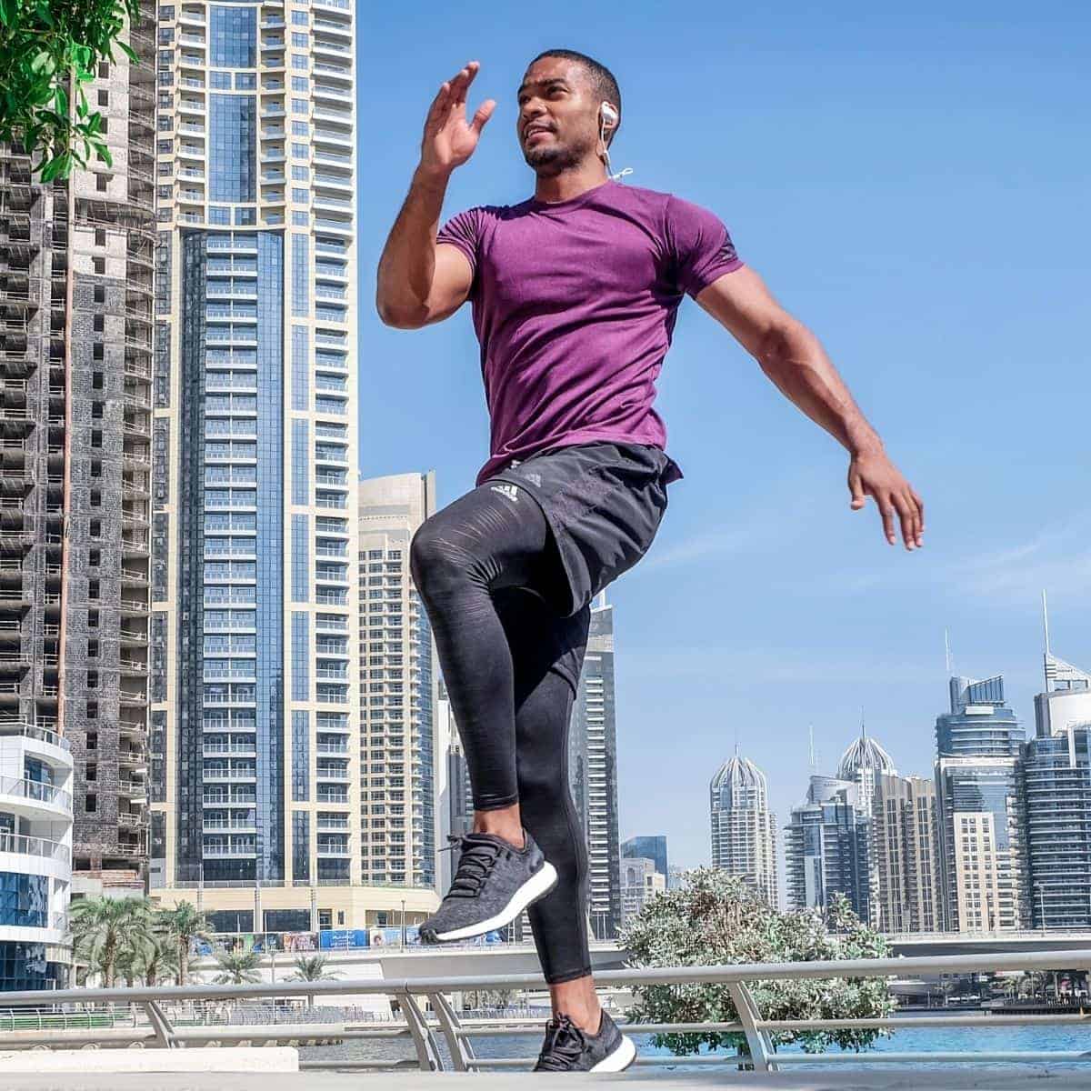 Person exercising outdoors with high-rise buildings in the background.