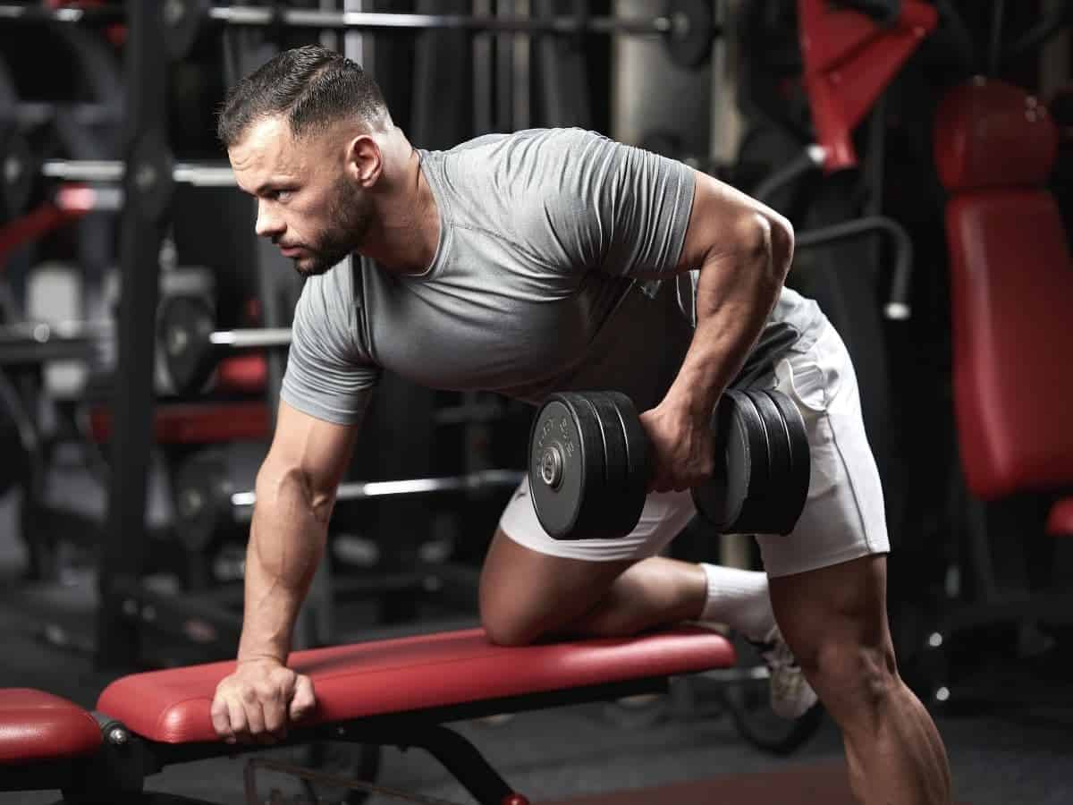 Person on a bench doing a dumbbell row.