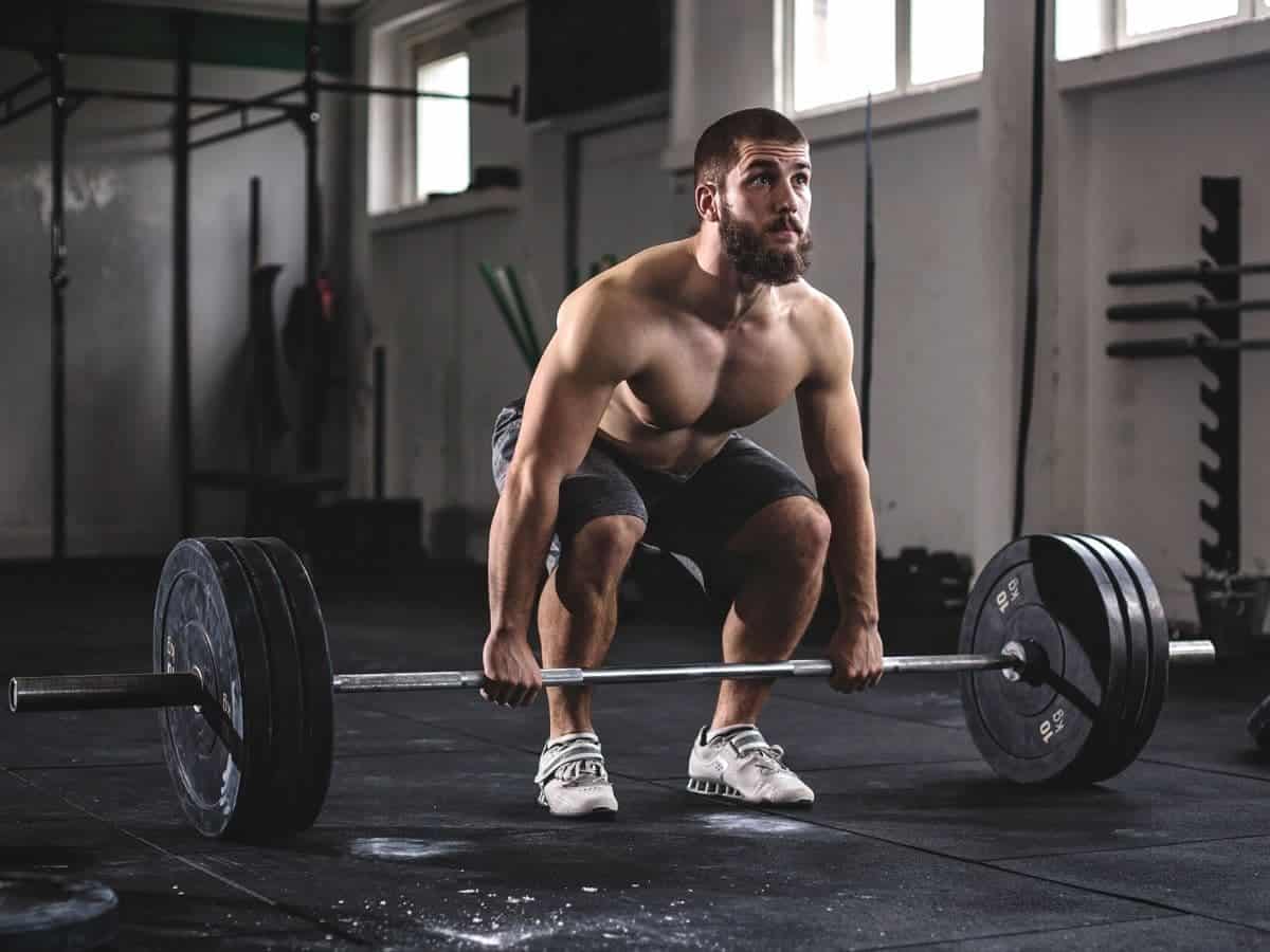 Shirtless person doing a deadlift.