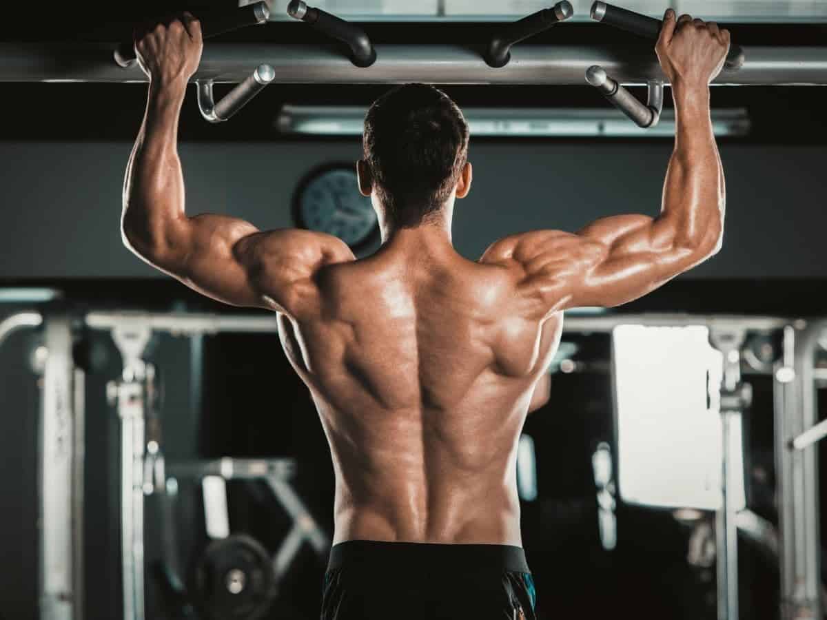 Shirtless person doing pull-ups.