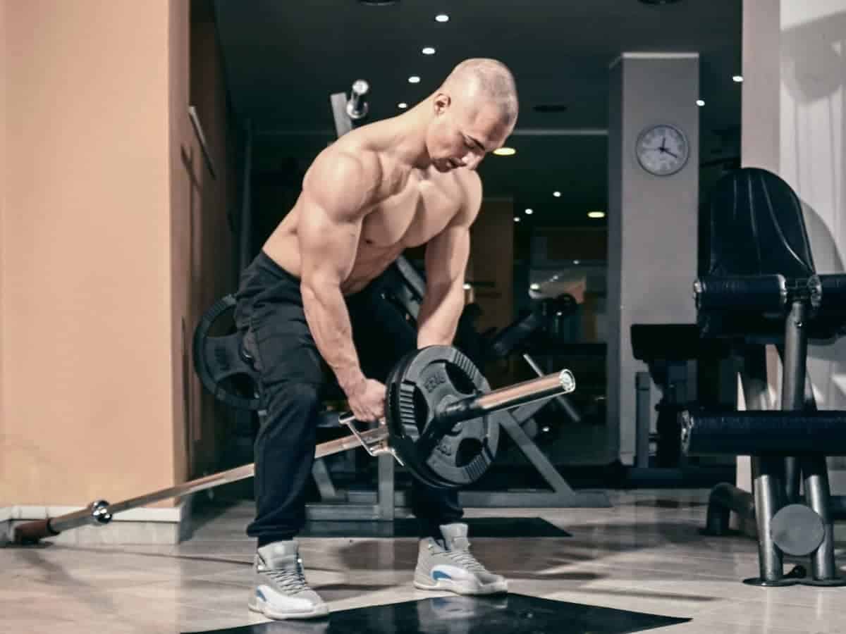 Shirtless person doing a T-bar row.