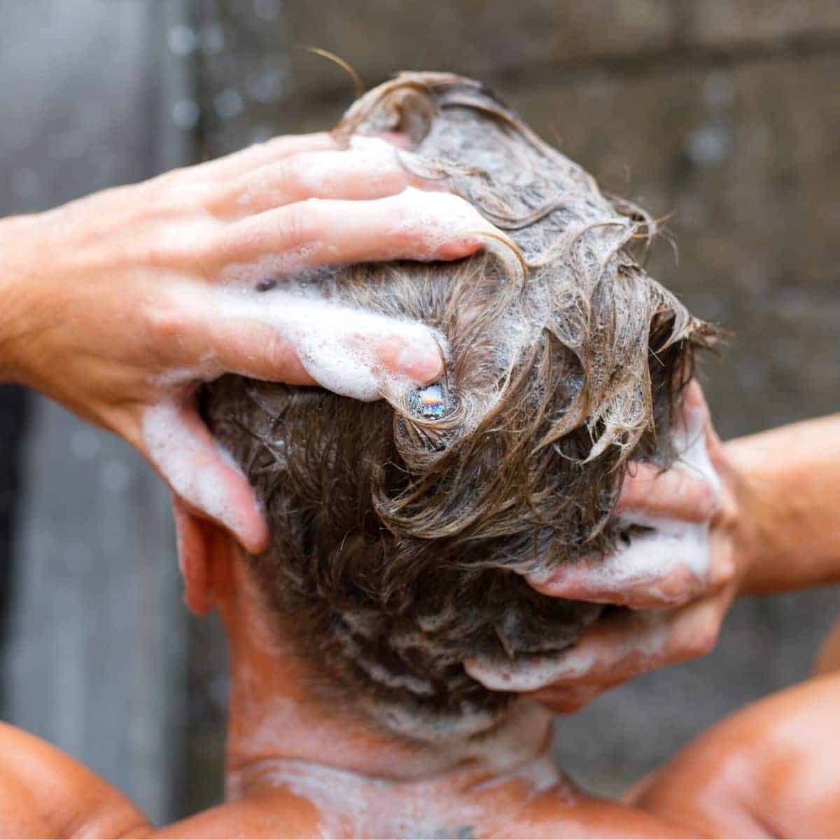 Back of a person's head while they're washing it.