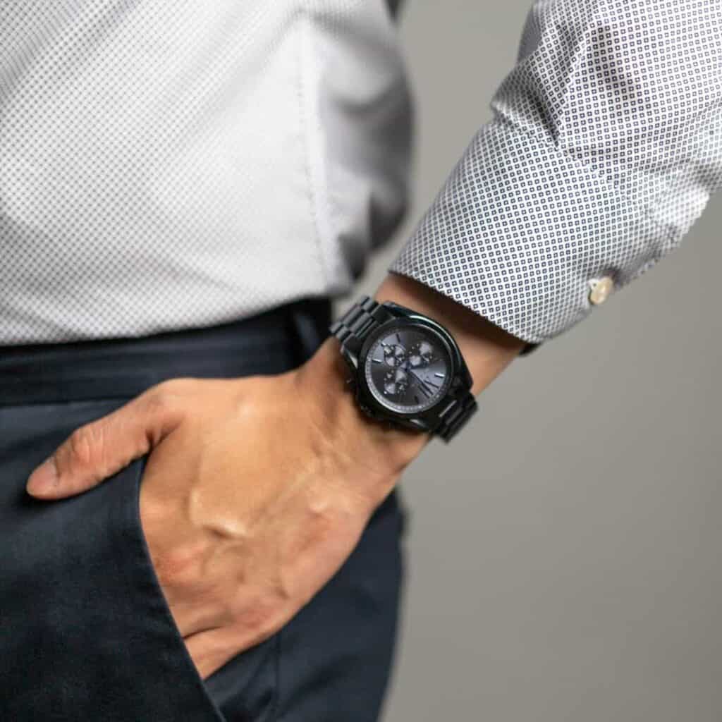 Close-up of a person's hand in their pocket while wearing a watch.