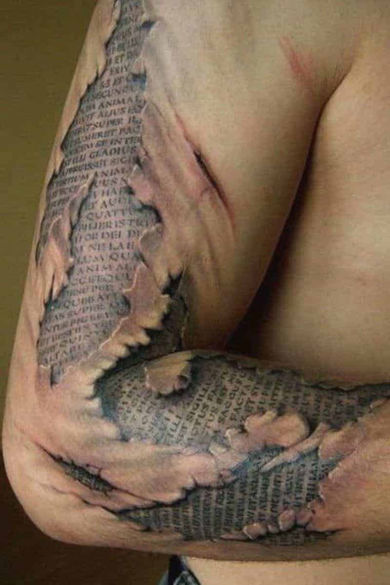 Tattoo of torn skin and letters on a person's arm.