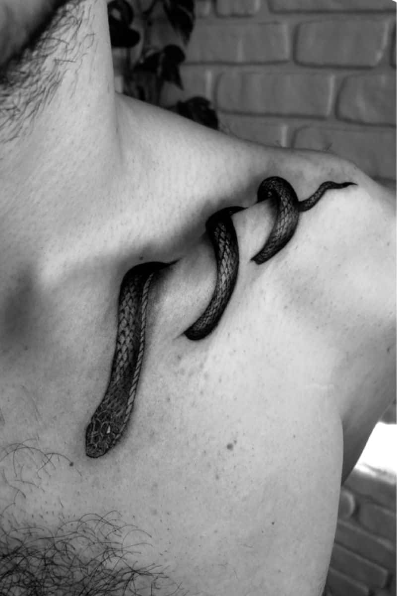 Snake tattoo on a person's collar bone.