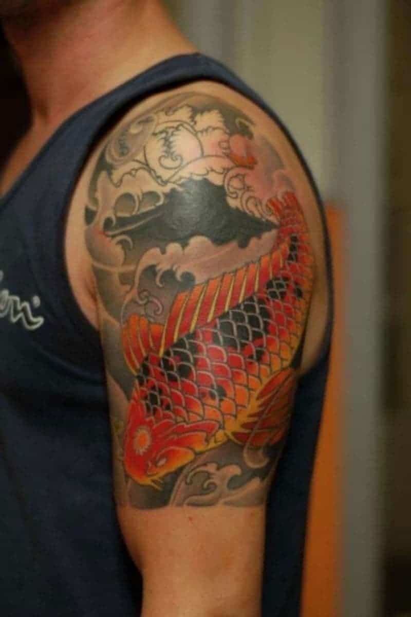 Person with a Japanese fish and waves shoulder tattoo.