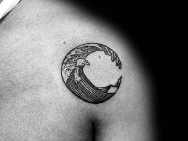 Person with a shoulder tattoo of a wave in a circle.
