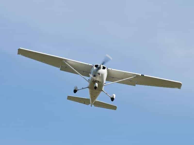 Bottom view of a small plane in the sky.