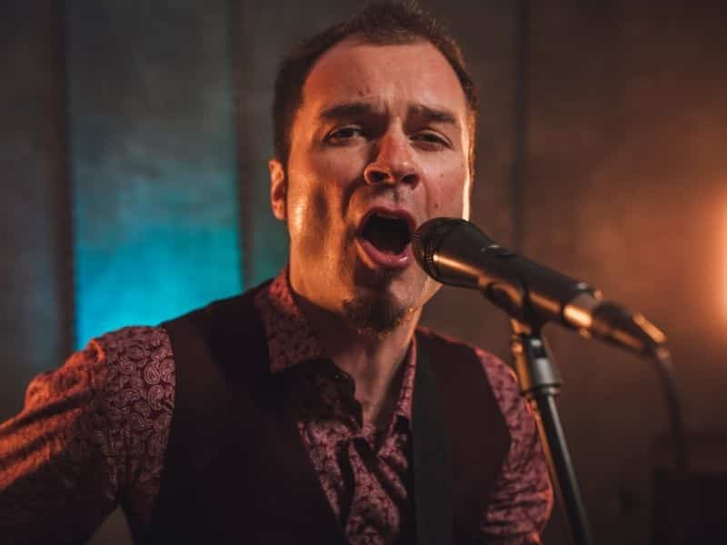 Man singing on a stage.