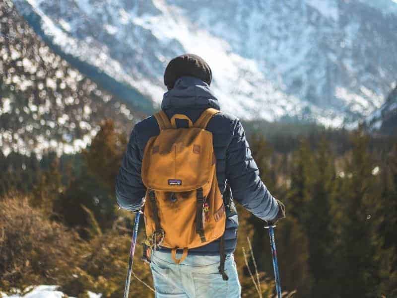 Person wearing a backpack and hiking in the mountains.