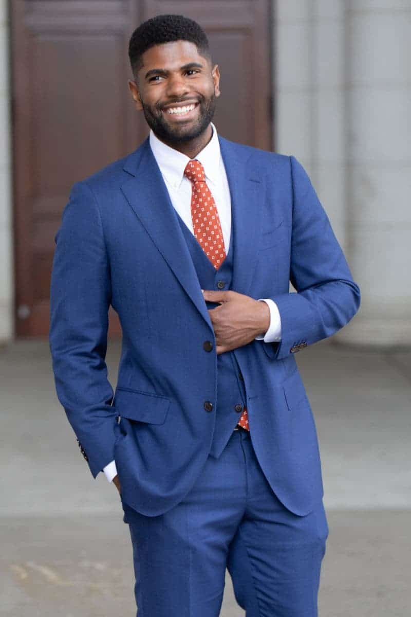 Person wearing a suit and smiling.