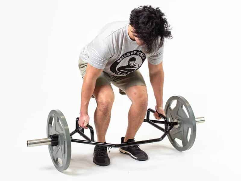 Person doing a deadlift with an open trap bar.