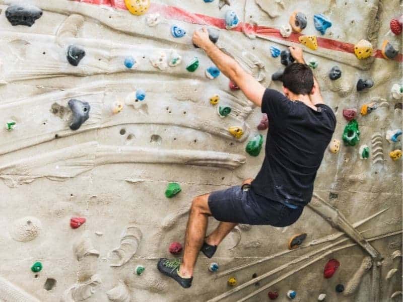 Person rock climbing indoors.