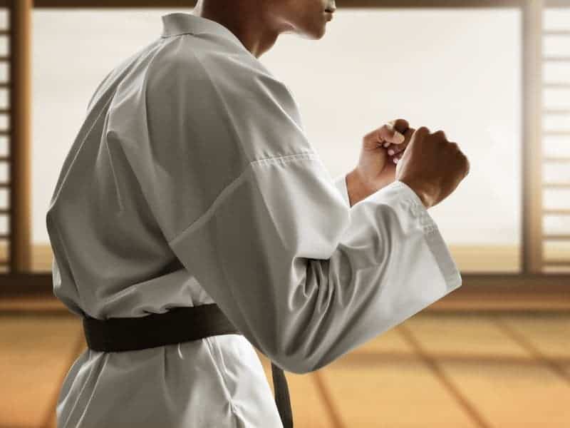 Person standing with their fists up in a martial arts uniform.