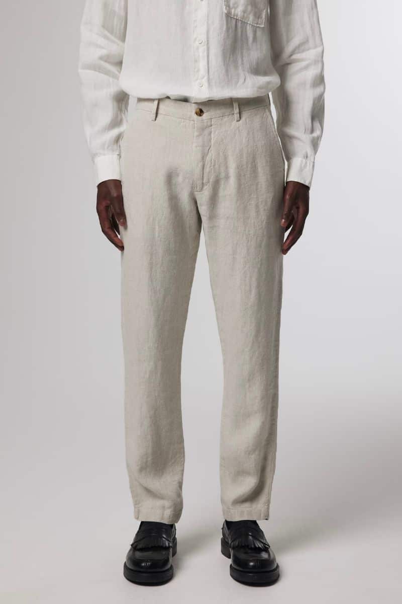 Lower half of a person wearing linen trousers.