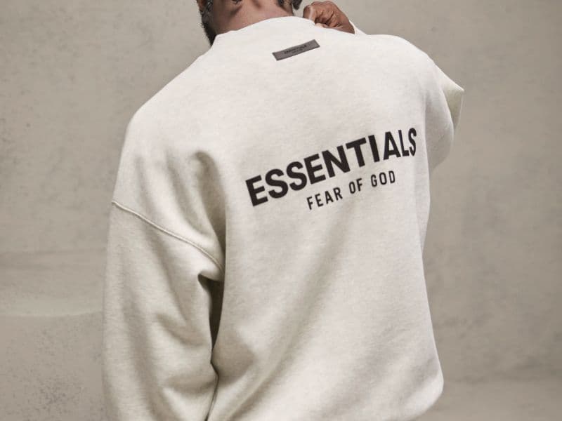 Back of a person wearing a Fear of God Essential sweater.