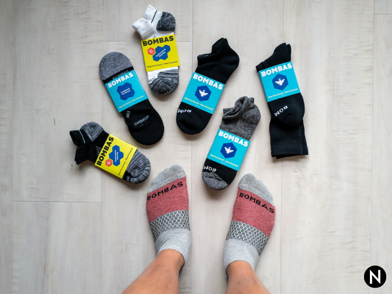Top-down of a person wearing socks with six socks surrounding their feet.