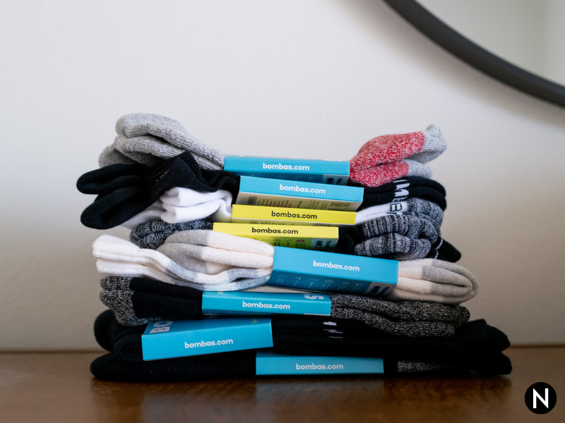 Stack of Bombas socks on a dresser.